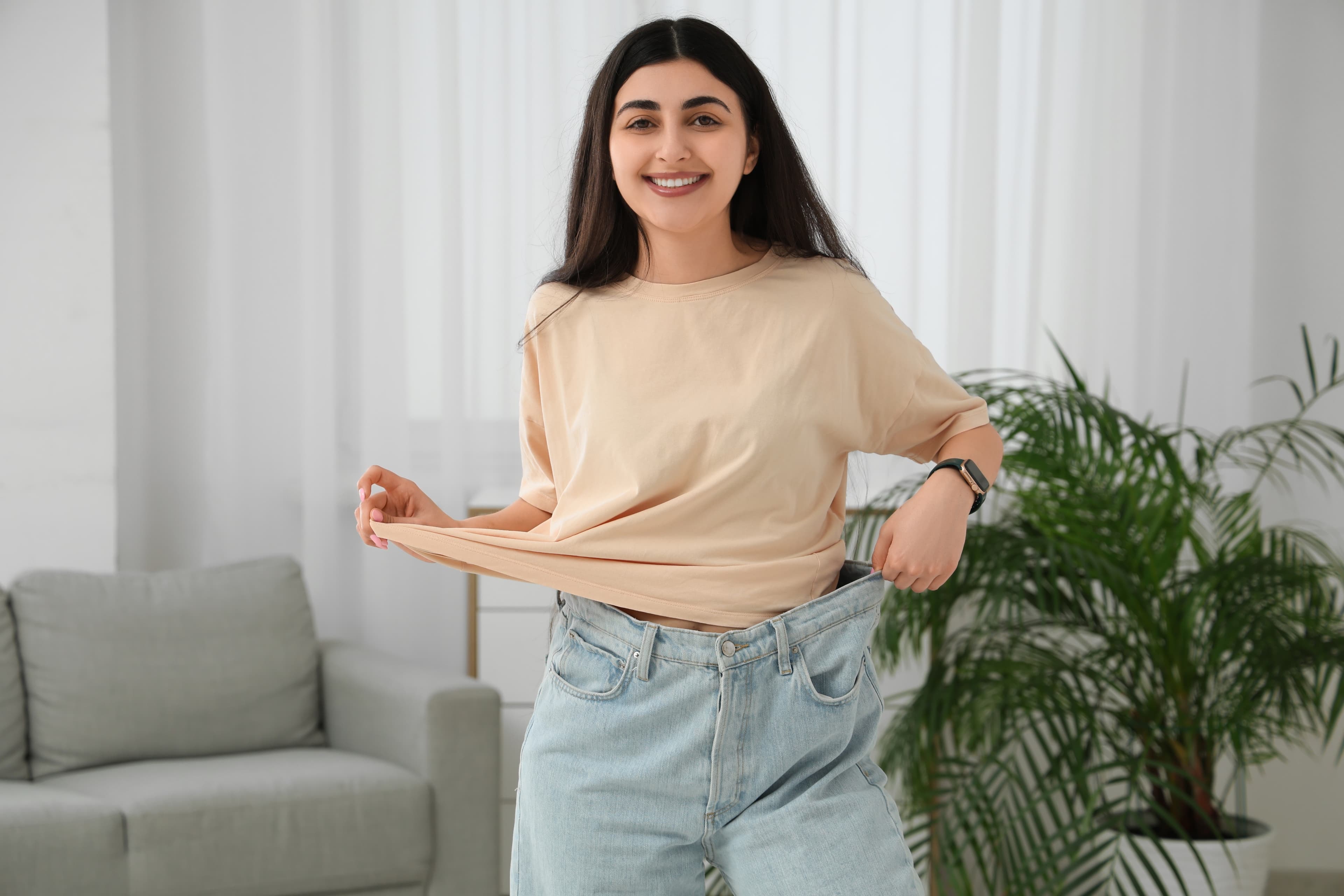 Woman measuring her waist during a weight loss journey