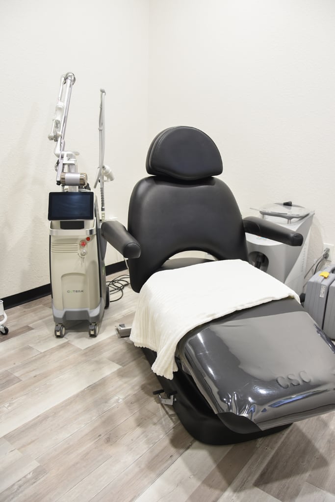Black and white reclining treatment chair in a Harmony Med Spa treatment suite