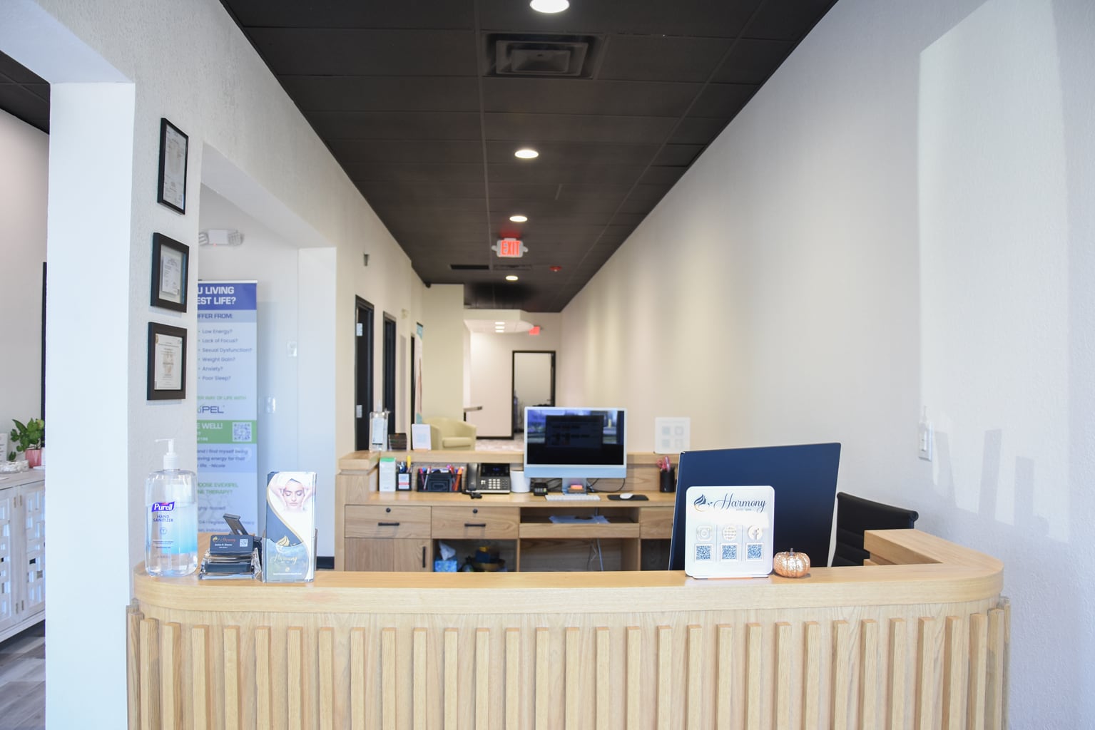Curved wood-front reception desk and hallway at Harmony Med Spa